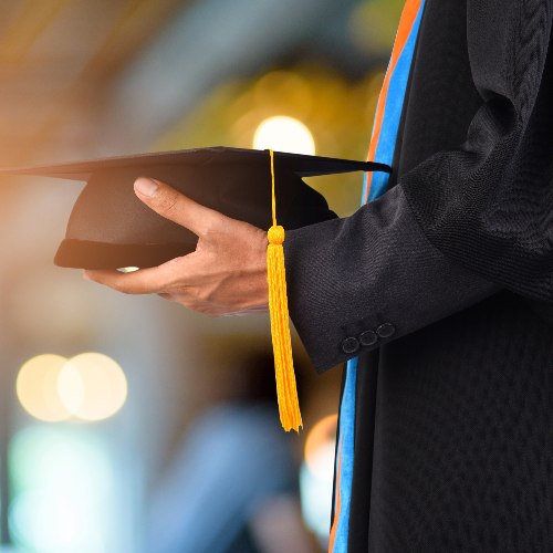 Graduation take a black yellow tassel in front of bokeh blurry background. Nirat.pix